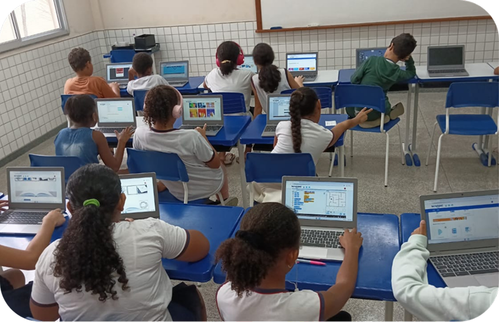Estudiantes en el aula haciendo actividades de programación por bloques de la Plataforma OLO en computadoras portátiles
